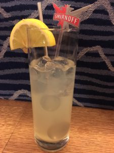 Cocktail glass with metal straw and Smirnoff branded plastic swizzle stick