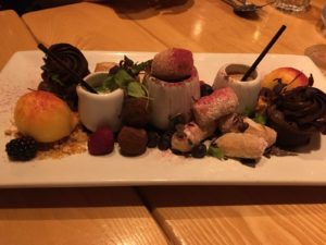 Dessert sharing plate with mini desserts and plastic straws in pots