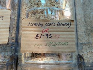 Oats in a dispenser with sign stating £1.95 per kg