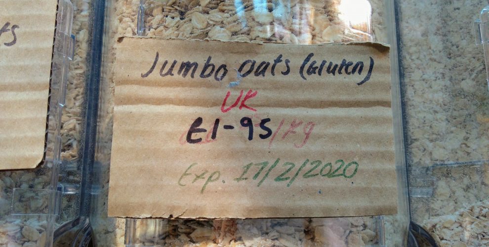 Oats in a dispenser with sign stating £1.95 per kg