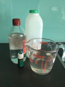 Ingredients for DIY fabric conditioner. Three different sized bottles and a jug on a kitchen counter.