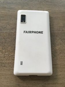 A Fairphone face down on a wooden surface. 