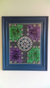 A piece of abstract art on a wall. Made of bits of tape including VHS.