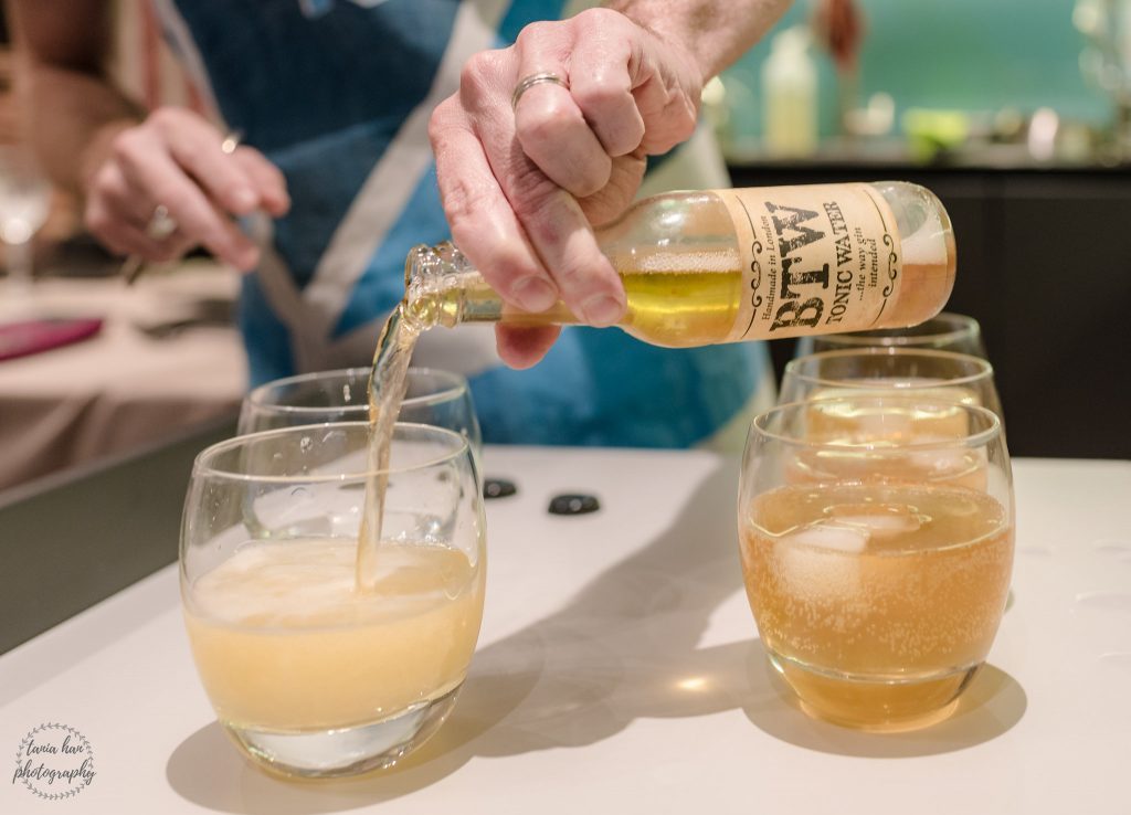 Glass bottle of tonic water being poured into a glass