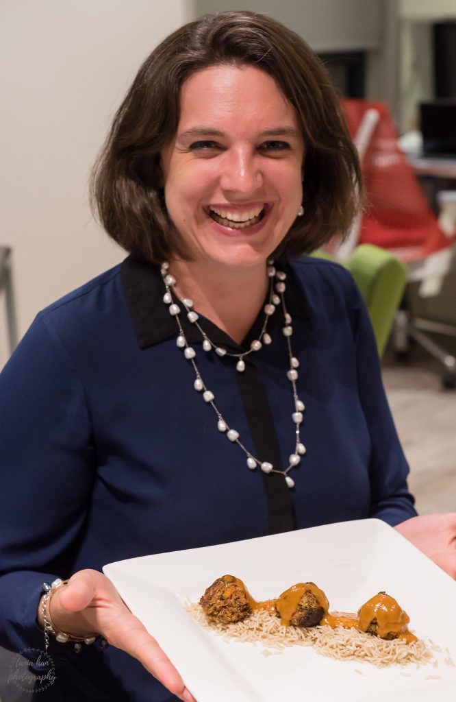 Woman holding plate with vegetarian balls on bed of rice