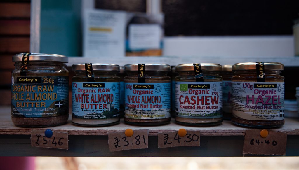 Shelf with row of jars containing different types of nut butter