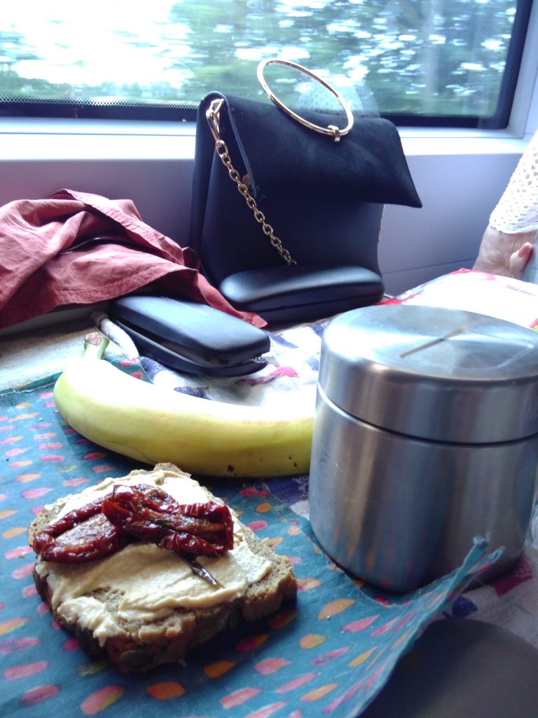 Sandwich, banana and metal food container on a train carriage table