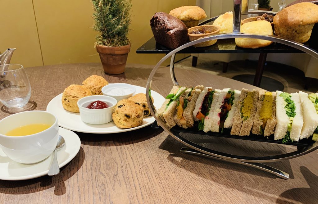 Afternoon tea with cake, sandwiches and tea cup