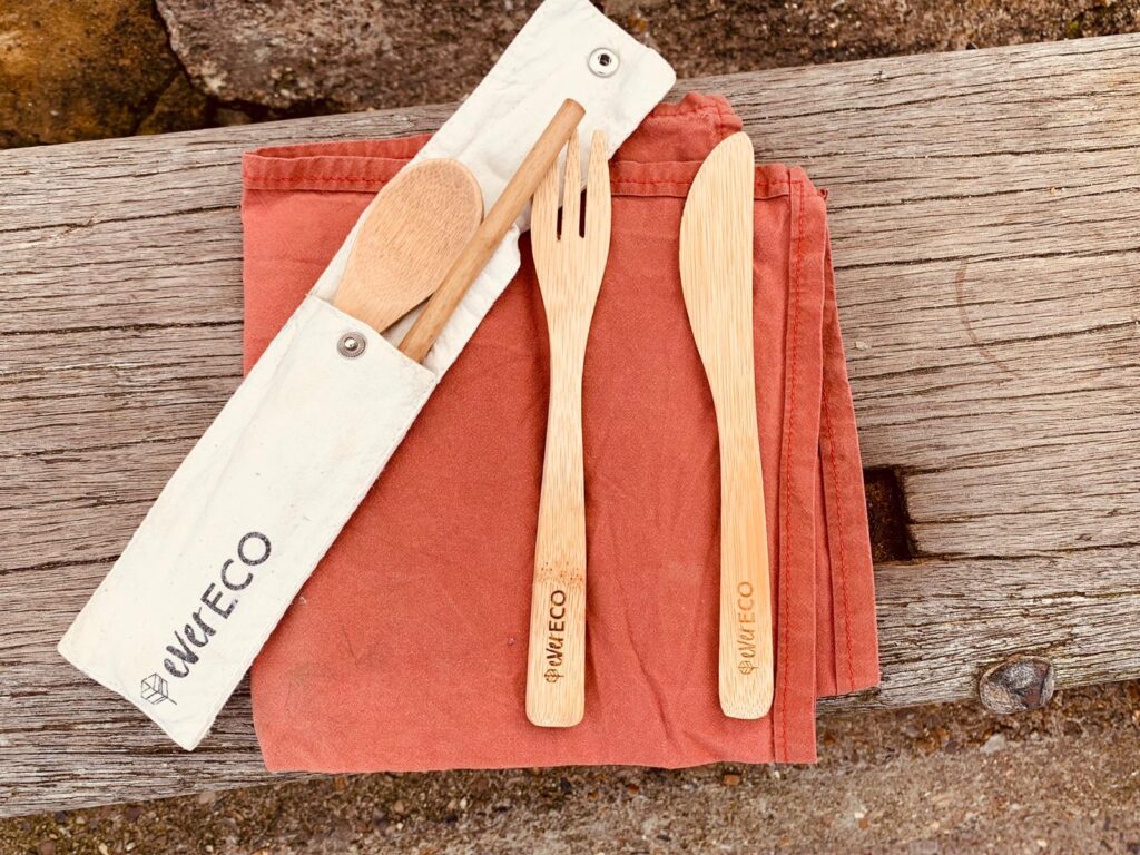Wooden reusable cutlery with a washable cloth napkin.