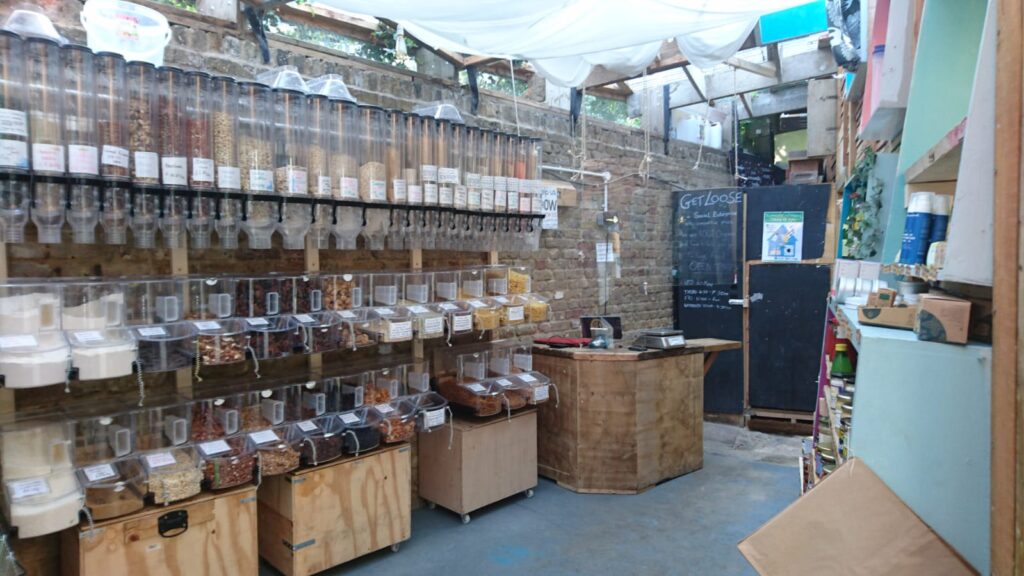 The inside of of a shop with dispensers full of loose food for customers to serve themselves and make up a present hamper.