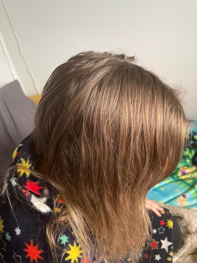 A woman's head with long blonde hair.