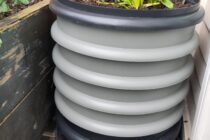 Grey round wormery with plants growing on top