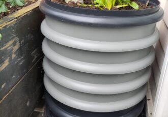 Grey round wormery with plants growing on top